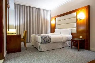 a hotel room with a bed and a table and a chair at Sadeen Amman Hotel in Amman
