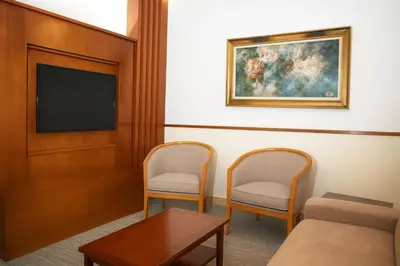 a waiting room with two chairs and a tv at Sadeen Amman Hotel in Amman