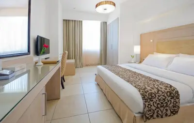 a hotel room with a large bed and a television at Toledo Amman Hotel in Amman