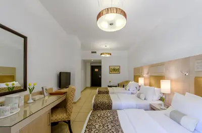 a hotel room with two beds and a desk at Toledo Amman Hotel in Amman