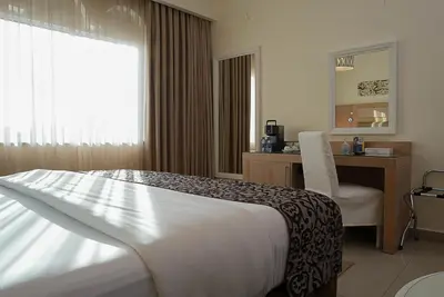 a bedroom with a bed and a desk and a chair at Toledo Amman Hotel in Amman