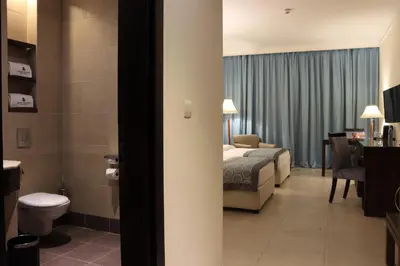 a hotel room with a bed and a bathroom at Dead Sea Spa Hotel in Sowayma