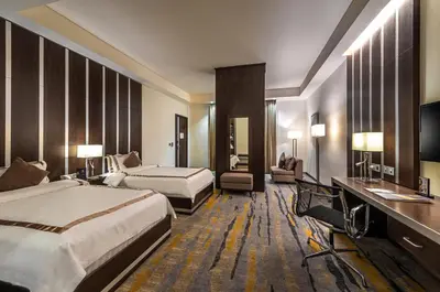 a hotel room with two beds and a television at Sulaf Luxury Hotel in Amman