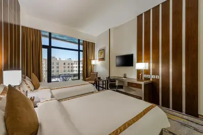 a hotel room with two beds and a television at Sulaf Luxury Hotel in Amman