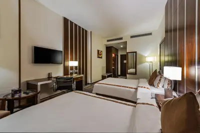 a hotel room with two beds and a television at Sulaf Luxury Hotel in Amman