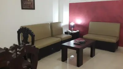 a living room with two chairs and a table at Al Fakher Hotel Apartments & Suites in Amman