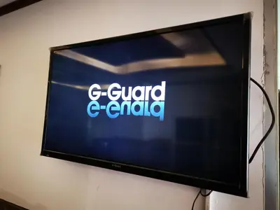 a flat screen television with the words g guard enfield at Al Fakher Hotel Apartments & Suites in Amman