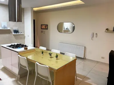 a kitchen with a table with chairs and a stove at Double Key by HR in Amman