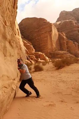 a man standing in the desert in a canyon at Bedouin life Camp in Wadi Rum