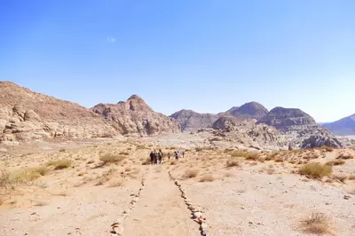 a group of people walking through the desert at Jordan Tracks Bedouin Camp in Wadi Rum