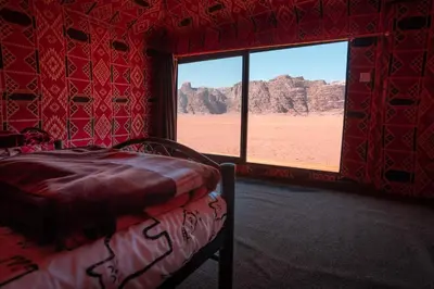 a bedroom with a bed and a view of the desert at Desert Bird Camp in Wadi Rum