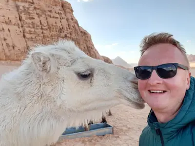 a man kissing a white cow in the desert at Wadi Rum Desert Secret in Wadi Rum