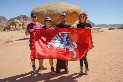 a group of people holding a flag in the desert at Wadi Rum Desert Secret in Wadi Rum