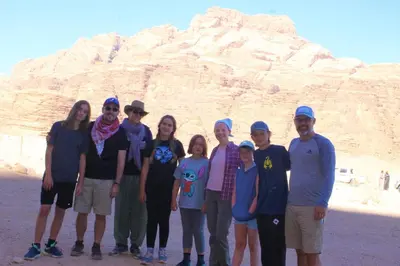 a group of people standing in front of a mountain at Wadi Rum Desert Secret in Wadi Rum
