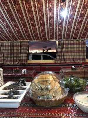 a table with a bowl of bread and a plate of food at Wadi Rum Starlight Camp in Wadi Rum