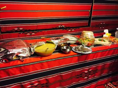 a table topped with different types of food on at Wadi Rum Starlight Camp in Wadi Rum