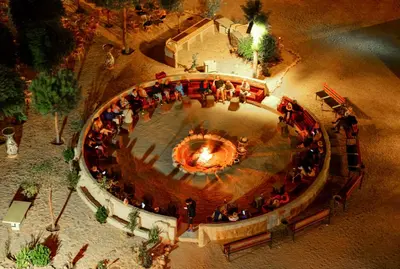a group of people standing around a large fountain at Little Petra Bedouin Camp in Al Ḩayy