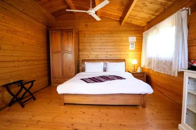 a bedroom with a bed in a wooden room at Mountain Breeze Lodge & Resort in Al Salt