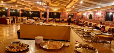 a restaurant with a counter with food on it at Hasan Zawaideh luxury camp 2 in Wadi Rum