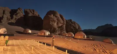a desert with domes in front of a mountain at Hasan Zawaideh luxury camp 2 in Wadi Rum