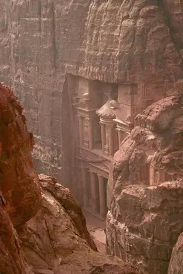 a stone building in a rock wall in a canyon at Esperanza Petra in Wadi Musa