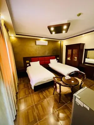 a hotel room with two beds and a table at Esperanza Petra in Wadi Musa