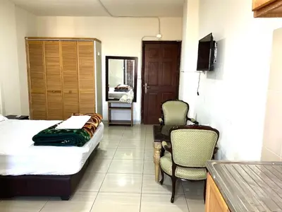 a bedroom with a bed and two chairs and a table at Al Qatal Building in Al Qasţal