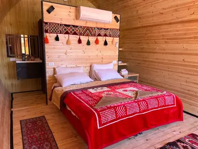 a bedroom with a bed in a wooden room at Wadi Rum Quiet Village Camp in Wadi Rum