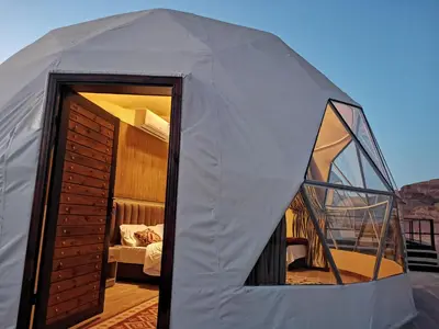 a white tent with a bedroom and a bed at Wadi Rum Dream Camp in Wadi Rum