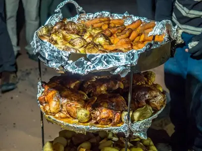 a three tiered tray of food with chickens and vegetables at Wadi Rum Dream Camp in Wadi Rum