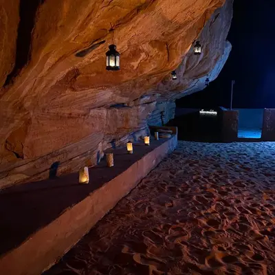 a stone wall with candles in a cave at Raka Camp & Tours in Wadi Rum