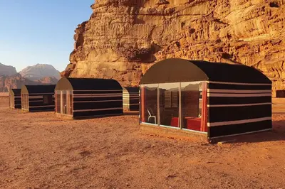 a row of tents in the desert near a mountain at Welcome to Wadi Rum Camp in Wadi Rum