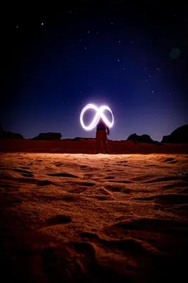 a person standing in the desert at night with a light up at Stargazing Camp & Tours in Wadi Rum