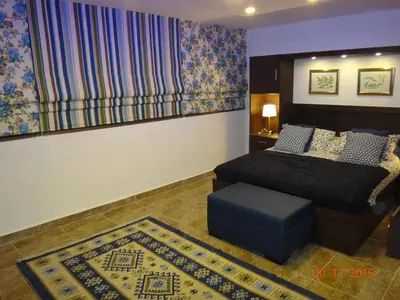 a bedroom with a bed and a blue ottoman at Royal Luxury Apartments & Studios 2 in Amman
