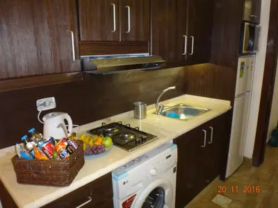 a kitchen with a counter with a sink and a dishwasher at Royal Luxury Apartments & Studios 2 in Amman