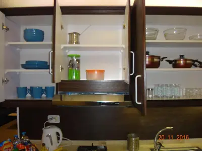 a kitchen cabinet with dishes and utensils in it at Royal Luxury Apartments & Studios 2 in Amman