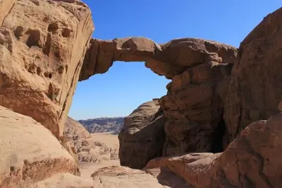 an arch in the rocks in the desert at Rumshines Camp in Wadi Rum