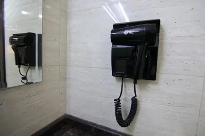a black phone hanging on a wall in a bathroom at Qaser Al-Sultan Hotel Suites in Amman