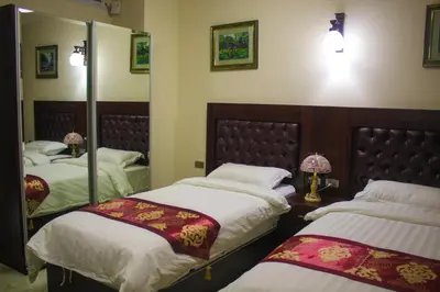 a bedroom with two beds and a mirror at Qaser Al-Sultan Hotel Suites in Amman