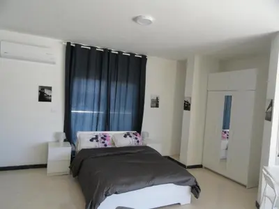 a bedroom with a bed and a large window at Diyarkom Apartment in Amman