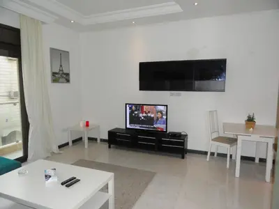 a living room with a flat screen tv on a wall at Diyarkom Apartment in Amman