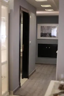 a room with a hallway with a mirror and a tv at Elite Residency in Amman