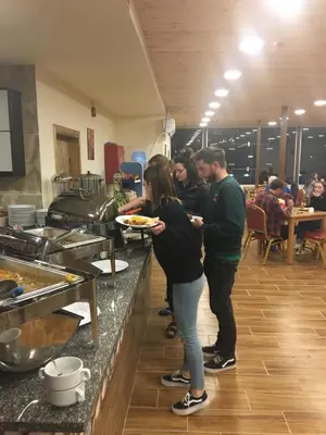 a group of people standing in a kitchen holding a plate of food at Petra Cabin Inn Hostel&Resturant in Wadi Musa