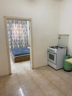 a kitchen with a stove and a bedroom with a bed at Sami Apartments in Amman