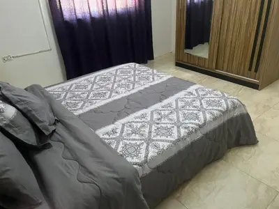 a bed sitting in a room with a mirror at Sami Apartments in Amman