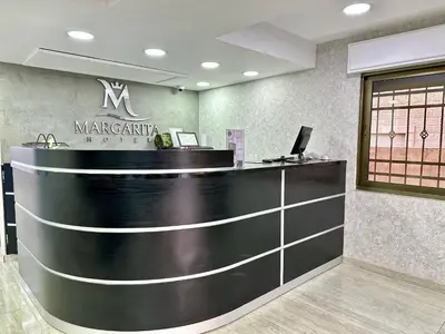 a lobby with a counter with a sign on it at Margarita Hotel in Amman