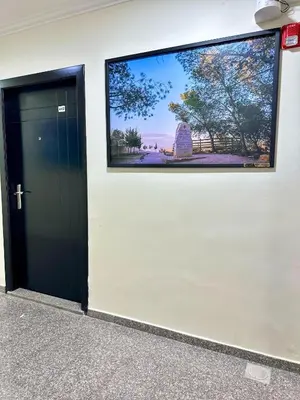 a black door in a white wall with a large window at Margarita Hotel in Amman