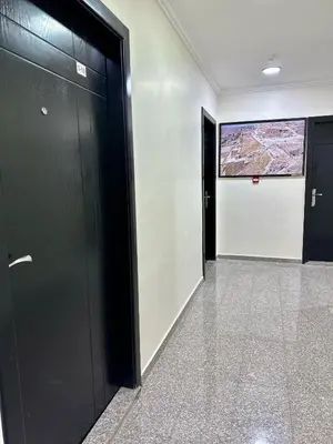 a hallway with two black doors and a sign on the wall at Margarita Hotel in Amman