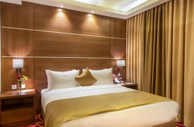 a bedroom with a large bed and wooden wall at Gerasa Hotel in Amman