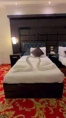 a bedroom with a large bed with a large headboard at Sparr Hotel in Amman